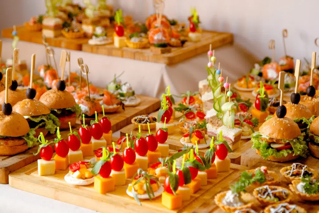 Buffet traiteur garni de mini-burgers, brochettes apéritives, verrines et amuse-bouches colorés.